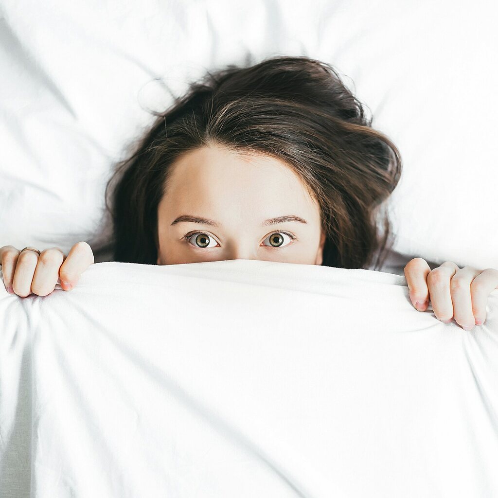 a woman resting under a blanket during trauma therapy in North Florida