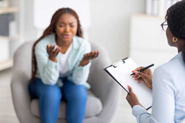 a woman consulting with a therapist while holding a cell phone