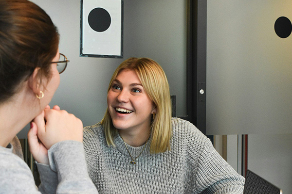 a woman and a man discussing mental health therapy options at a computer screen