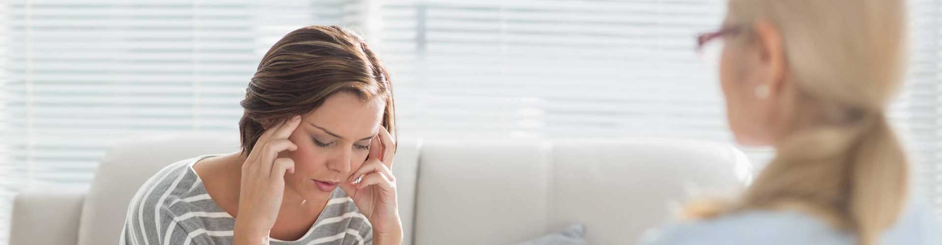 a woman on a couch discussing her progress with a therapist over the phone